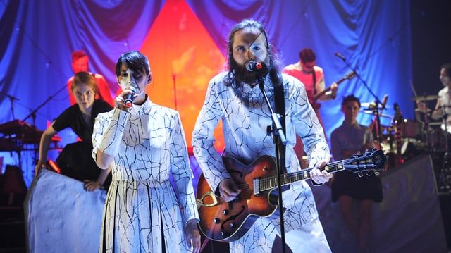 Basler Band «The bianca Story» in weissen Kostümen vor bunt geleuchtetem Hintergrund. Basler Band «The bianca Story» in weissen Kostümen vor bunt geleuchtetem Hintergrund.