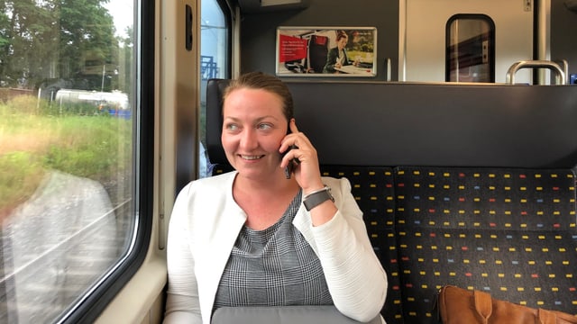 Liz im Zug am Telefonieren.