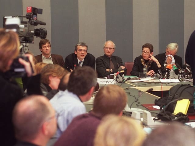 Eine Gruppe von Männern und eine Frage gibt eine Pressekonferenz. Eine Gruppe von Männern und eine Frage gibt eine Pressekonferenz.