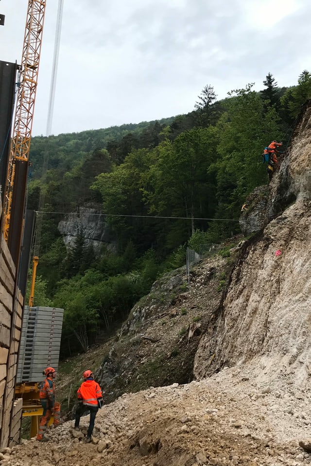 Kletterer an Felswand bei Baustelle. Kletterer an Felswand bei Baustelle.