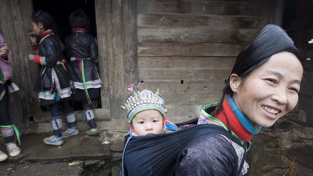 Eine Frau und Kinder der Dong, in traditioneller Kleidung Eine Frau und Kinder der Dong, in traditioneller Kleidung