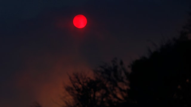 Rauch färbt den Himmel über Malibu, die Sonne scheint rot. Rauch färbt den Himmel über Malibu, die Sonne scheint rot.
