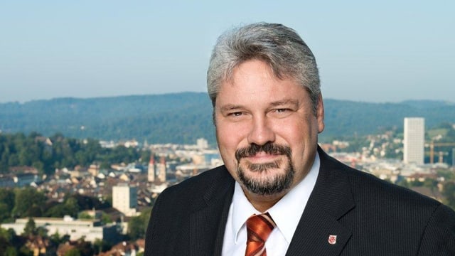 Mann mit schwarzem Azug und Krawatte vor Stadt Winterthur Mann mit schwarzem Azug und Krawatte vor Stadt Winterthur