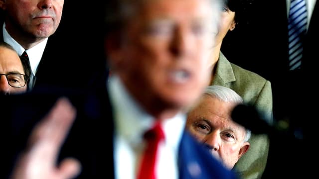 Im Vordergrund Donald Trump in der Unschärfe. Hinter ihm schaut Vizepräsident Jeff Sessions hervor. Im Vordergrund Donald Trump in der Unschärfe. Hinter ihm schaut Vizepräsident Jeff Sessions hervor.