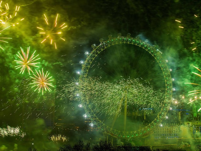 Das Riesenrad im grünen Licht von explodierendem Feuerwerk. Das Riesenrad im grünen Licht von explodierendem Feuerwerk.