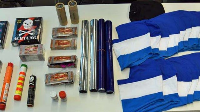 Konfiszierte Knallkörper, Pyrofackeln und Sturmhauben liegen auf einem Tisch. Konfiszierte Knallkörper, Pyrofackeln und Sturmhauben liegen auf einem Tisch.
