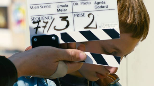 Filmklappe. Dahinter ein Junge. Filmklappe. Dahinter ein Junge.