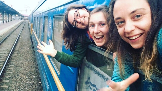 Drei junge Frauen schauen aus einem Zugfenster. Drei junge Frauen schauen aus einem Zugfenster.