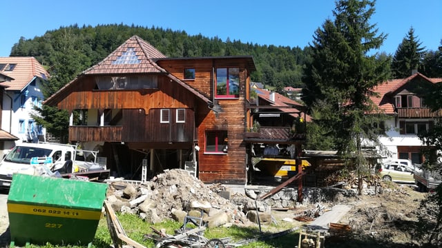 Garten mit Schlamm und Erde, dahinter Haus, Fassade weg. Garten mit Schlamm und Erde, dahinter Haus, Fassade weg.