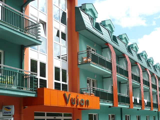 Eine hotelähnliche Fassade in Orange und Türkis.