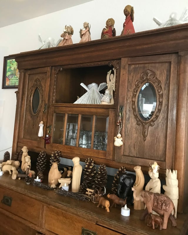 Holzregal mit Krippenfiguren und Engeln.