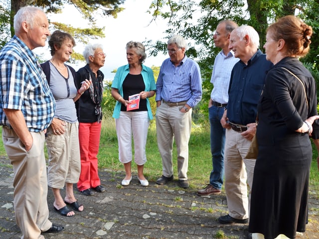 Eine Gruppe von Menschen steht in einem Halbkreis. Eine Gruppe von Menschen steht in einem Halbkreis.