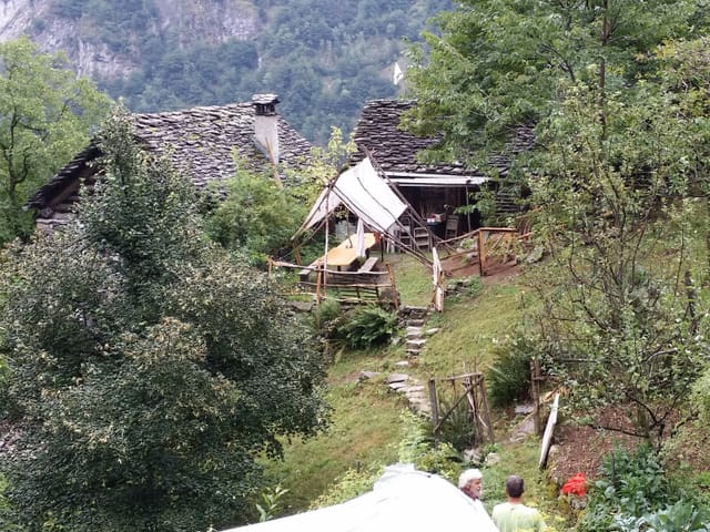 Blick auf das Öko-Dorf mit zwei alten Gebäuden mit Steindächern.