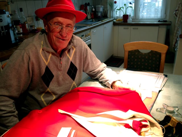 Eduard Roth sitzt am Tisch, vor ihm das rote Hans-Roth-Ehrenkleid. Eduard Roth sitzt am Tisch, vor ihm das rote Hans-Roth-Ehrenkleid.