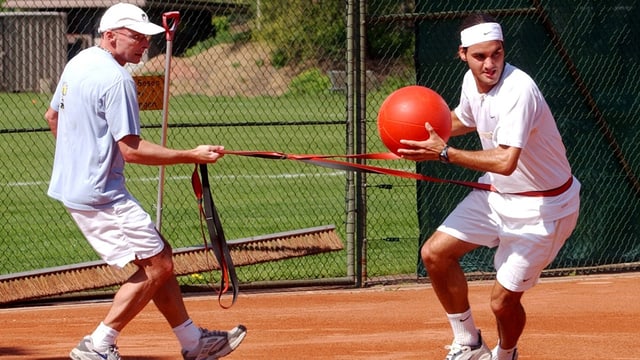 Paganini macht mit Federer eine Sprint-Übung mit Ball und Gummizug. Paganini macht mit Federer eine Sprint-Übung mit Ball und Gummizug.