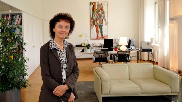Bundesrätin Widmer-Schlumpf in ihrem Büro: Rechts ein beiges Zweiersofa, im Hintergrund ihr Schreibtisch mit einem hochforamtigen Bild an der Wand dahinter Bundesrätin Widmer-Schlumpf in ihrem Büro: Rechts ein beiges Zweiersofa, im Hintergrund ihr Schreibtisch mit einem hochforamtigen Bild an der Wand dahinter