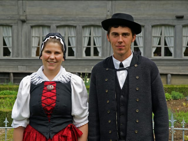 Trachtenpaar vor Bauernhaus. Trachtenpaar vor Bauernhaus.