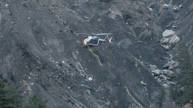 Helikopter fliegt vor gebirgigem Gelände. Helikopter fliegt vor gebirgigem Gelände.