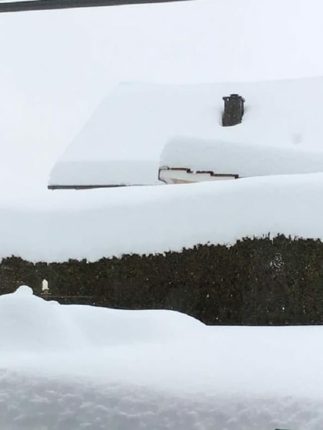 Ein Hausdach voller Schnee