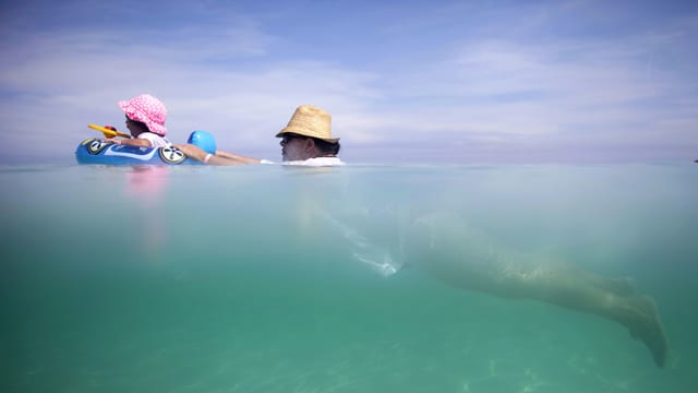 Mann und Kind beim Schwimmen im Meer Mann und Kind beim Schwimmen im Meer