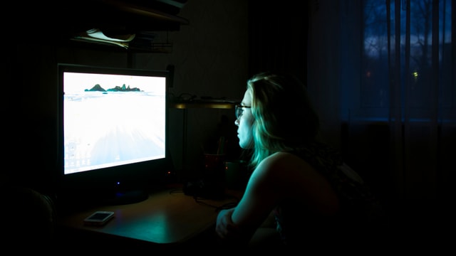 eine junge Frau schaut am Computer eine Sendung eine junge Frau schaut am Computer eine Sendung