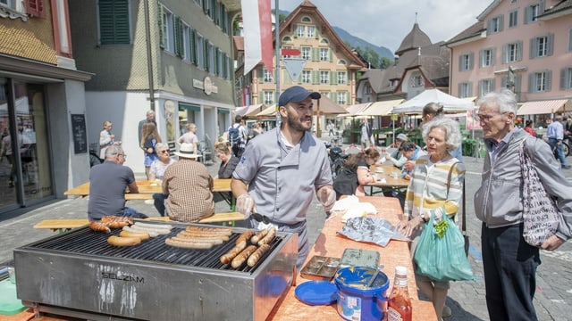 Ein Mann und eine Frau kaufen Würste auf dem Wochenmarkt in Sarnen Ein Mann und eine Frau kaufen Würste auf dem Wochenmarkt in Sarnen