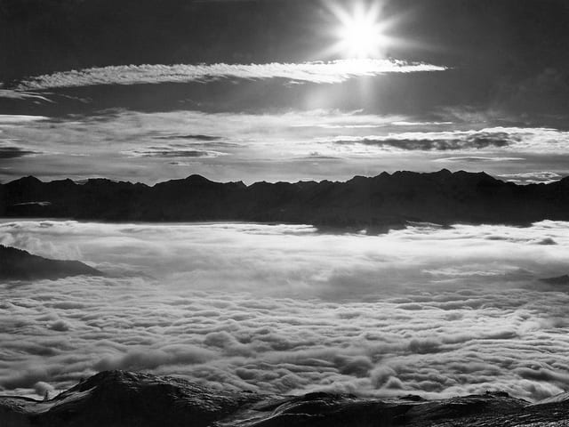Blick über ein Nebelmeer im Gegenlicht in Schwarz-Weiss
