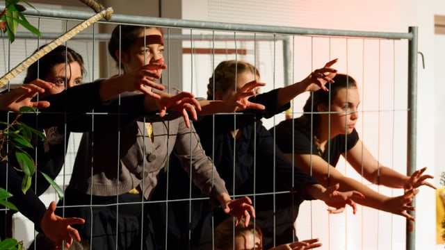 Darstellerinnen strecken ihre Hände durch Gitterstäbe. Darstellerinnen strecken ihre Hände durch Gitterstäbe.