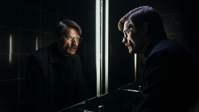 Der hweld des Films steht vor einem Spiegel. Der hweld des Films steht vor einem Spiegel.