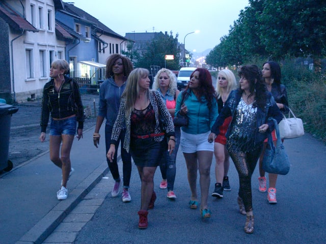 Eine Gruppe von Frauen spatziert die Strasse entlang. Eine Gruppe von Frauen spatziert die Strasse entlang.
