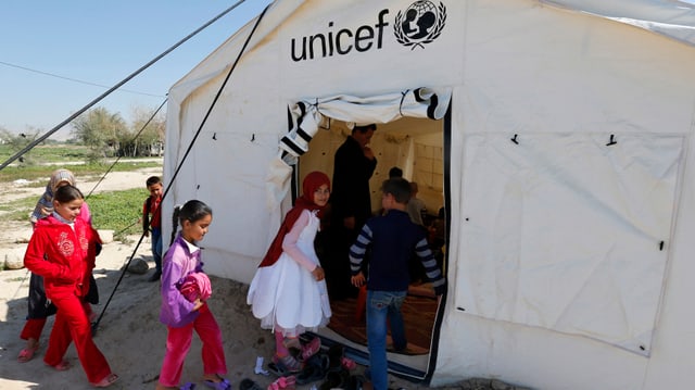 Kinder betreten ein UNICEF-Zelt. Kinder betreten ein UNICEF-Zelt.