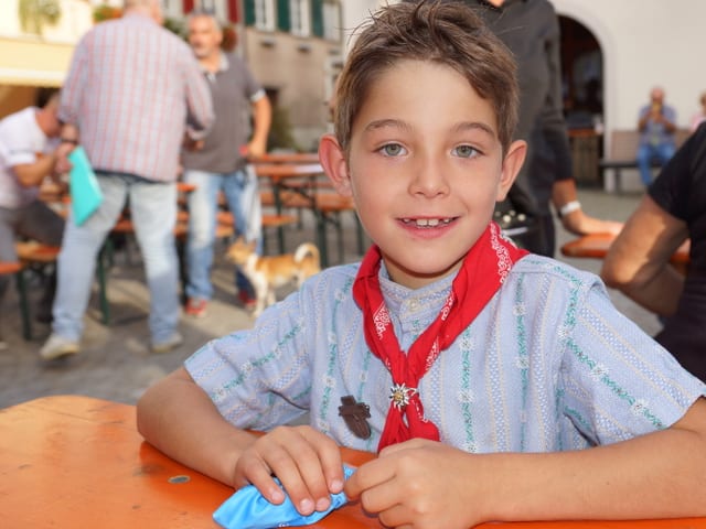 Ein Bub mit Sennenhemd und rotem Halstuch.