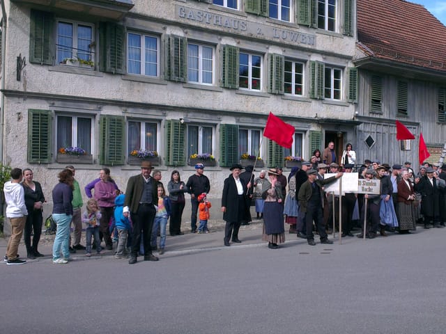 Leute vor Gasthaus Löwen, in moderner und historischer Kleidung