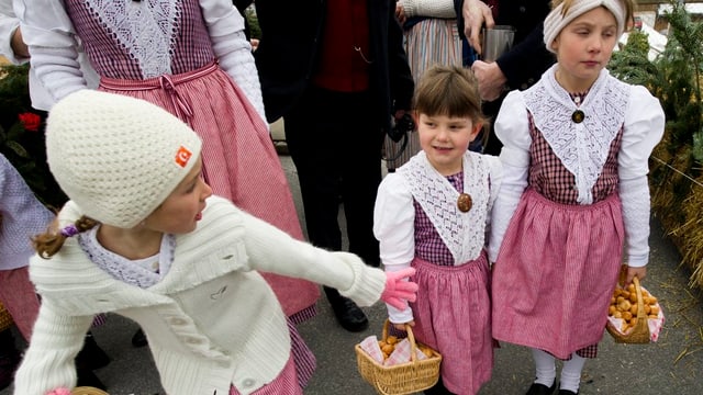 Drei Mädchen mit traditionellen rosa Kleidern und Körben. Drei Mädchen mit traditionellen rosa Kleidern und Körben.