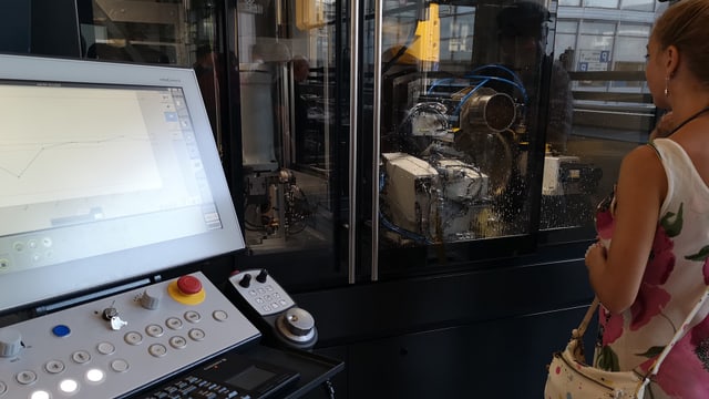 Frau schaut in computergesteuerte Maschine. Frau schaut in computergesteuerte Maschine.
