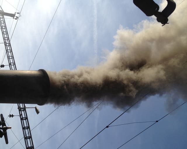 Dunkler Rauch steigt aus Lokomotiven-Kamin Dunkler Rauch steigt aus Lokomotiven-Kamin