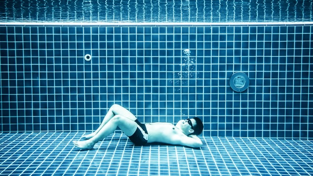 Mann liegt im Pool unter Wasser. Mann liegt im Pool unter Wasser.