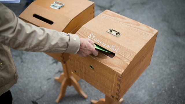 Ein Mann wirft einen Stimmzettel in die Urne. Ein Mann wirft einen Stimmzettel in die Urne.