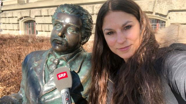 Selfie von Reporterin mit einer Albert Einstein Statue, die auf einer Bank sitzt Selfie von Reporterin mit einer Albert Einstein Statue, die auf einer Bank sitzt