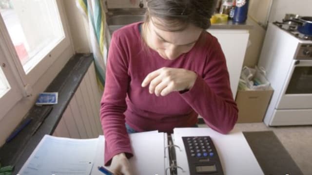 Eine Frau berechnet ihre Krankenkasse. Eine Frau berechnet ihre Krankenkasse.