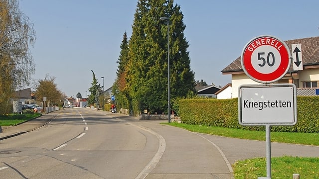 Ortsschild von Kriegstetten neben unbefahrener Strasse. Ortsschild von Kriegstetten neben unbefahrener Strasse.