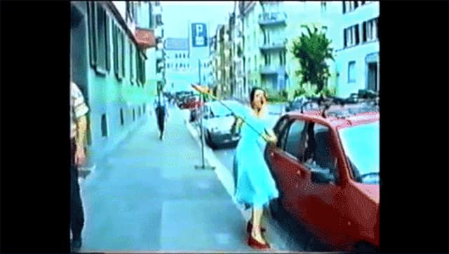 Frau schlägt Autoscheibe mit Blume ein. Frau schlägt Autoscheibe mit Blume ein.