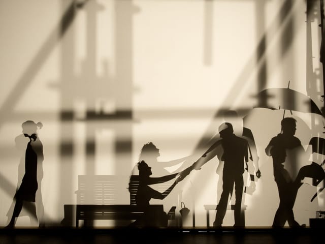 Die Silhouetten von Schauspielern hinter einer Leinwand. Die Silhouetten von Schauspielern hinter einer Leinwand.