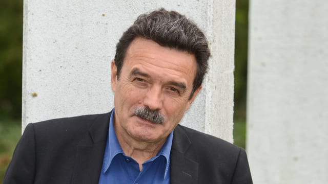 Edwy Plenel schaut vor einer Betonwand skeptisch in die Kamera. Edwy Plenel schaut vor einer Betonwand skeptisch in die Kamera.