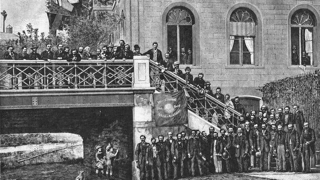Viele Männer stehen vor einer Treppe vor einem grossen Haus in der Stadt. Viele Männer stehen vor einer Treppe vor einem grossen Haus in der Stadt.