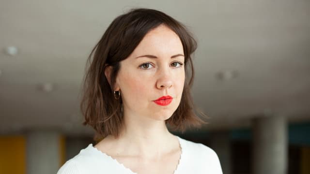 Frau mit braunen Haaren und rotem Lippenstift schaut in die Kamera Frau mit braunen Haaren und rotem Lippenstift schaut in die Kamera