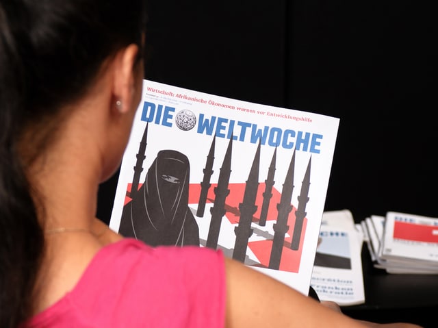 Frau schaut sich «Weltwoche»-Cover an. Frau schaut sich «Weltwoche»-Cover an.