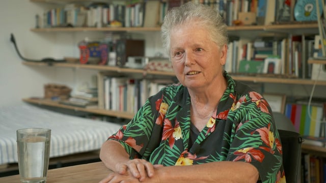 Künstlerin Miriam Cahn sitzt bei einem Glas Wasser vor einer Bücherwand. Künstlerin Miriam Cahn sitzt bei einem Glas Wasser vor einer Bücherwand.