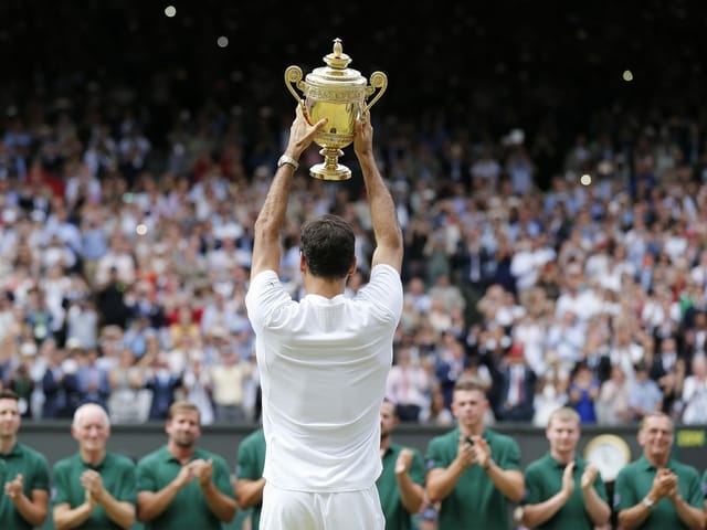 Roger Federer von hinten, wie er dem Publikum die Trophäe präsentiert. Roger Federer von hinten, wie er dem Publikum die Trophäe präsentiert.