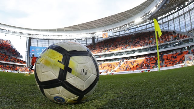 WM-Fussball in einem russischen Stadion aus der Nähe fotografiert mit einem Teil der Zuschauerränge im Hintergrund. WM-Fussball in einem russischen Stadion aus der Nähe fotografiert mit einem Teil der Zuschauerränge im Hintergrund.